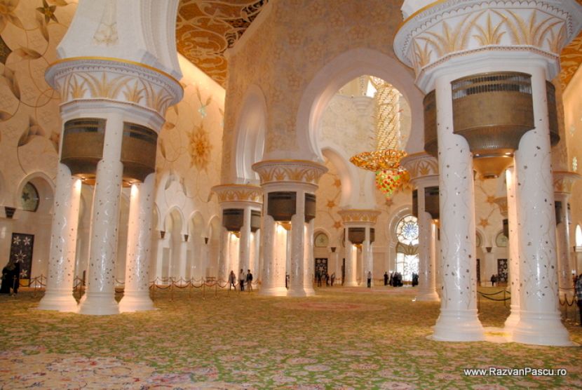 Sală vastă cu coloane, arcade și covor ornamentat