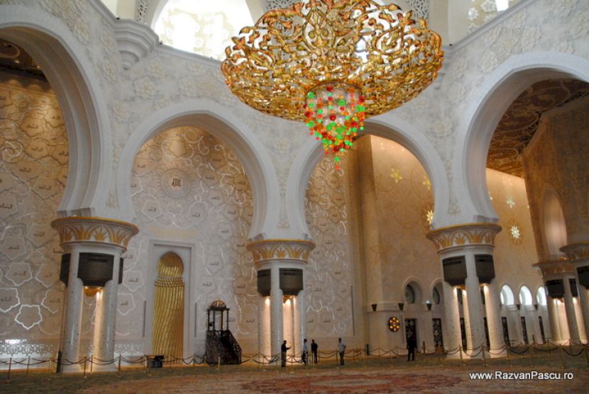 Candelabru colorat suspendat într-un interior cu arcade albe
