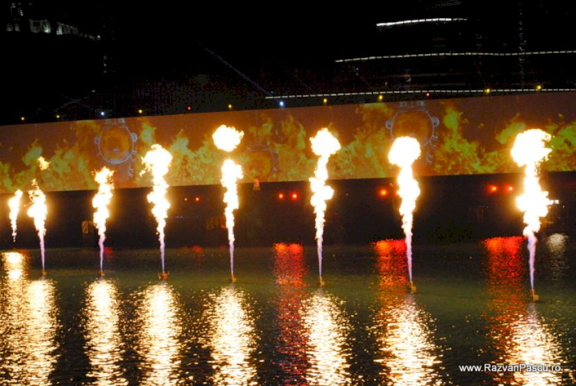 Jeturi de foc reflectate în apă pe timp de noapte