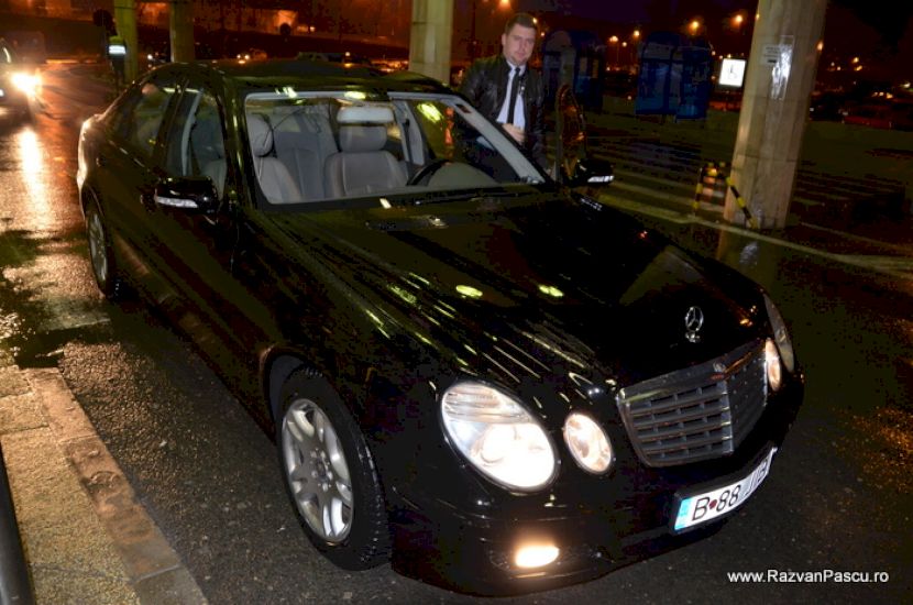 Mașină neagră expusă într-un interior cu iluminare caldă