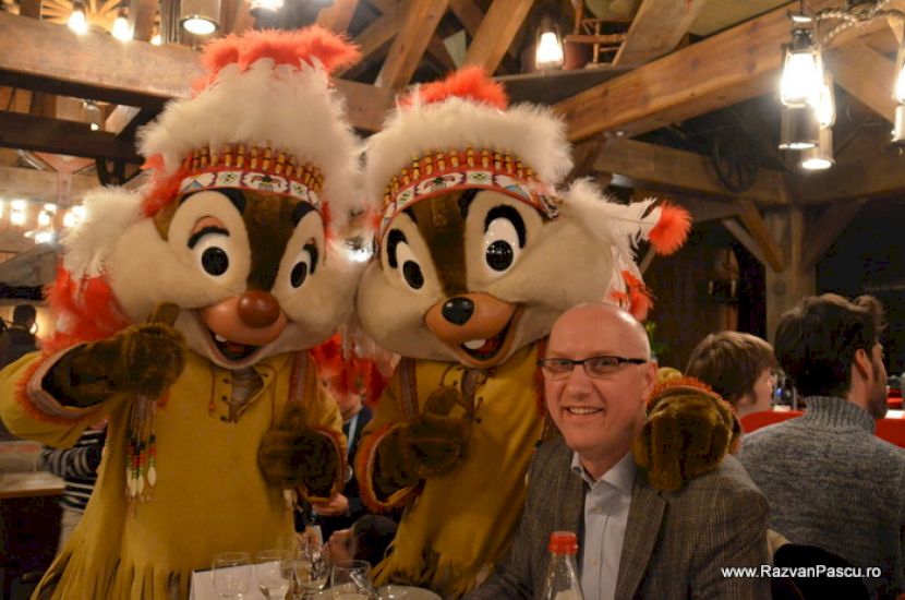 Două persoane lângă personaje Disney în costume festive