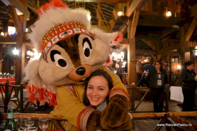 Femeie lângă un personaj Disney în costum festiv