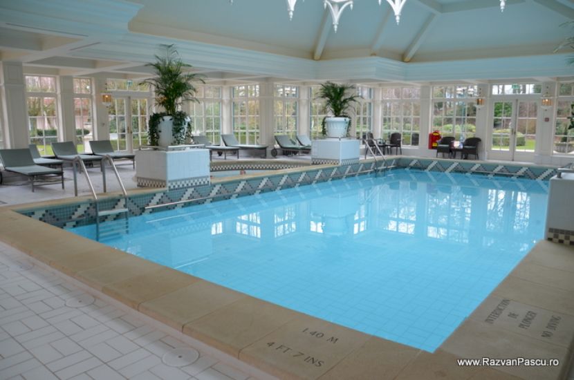 Piscină interioară într-o sală luminoasă cu ferestre