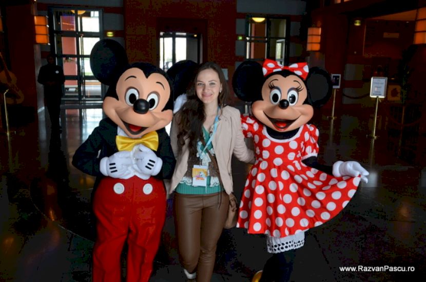 Femeie între personaje costumate ca Mickey și Minnie Mouse