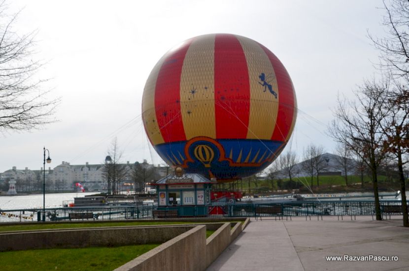 Balon multicolor ridicat lângă un lac și promenade