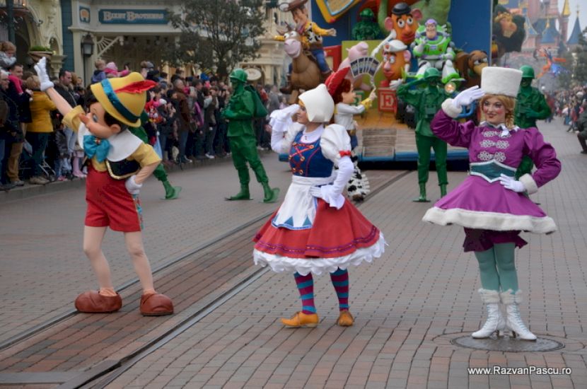 Participanți în costume colorate dansând pe traseul paradei