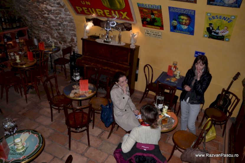 Persoane așezate într-un bar cu mese mici