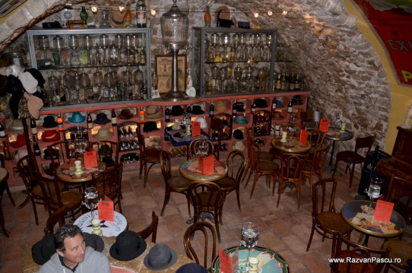 Interior de bar cu mese și sticle expuse
