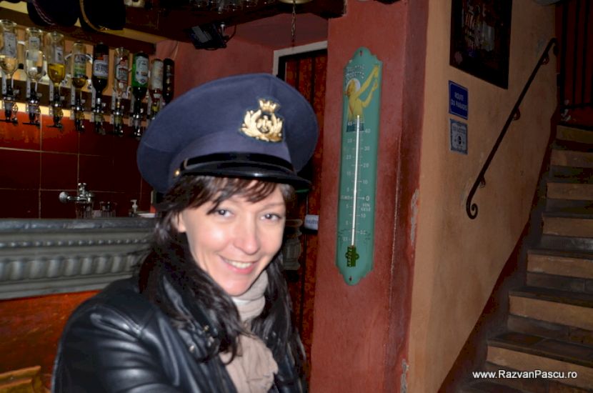 Femeie cu pălărie într-un interior de bar