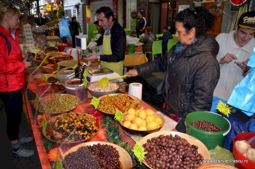 Vânzător și cumpărători lângă legume și fructe