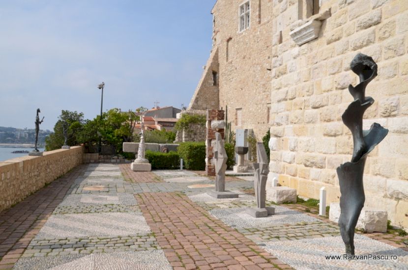 Sculptură verticală lângă zidul unei clădiri de piatră
