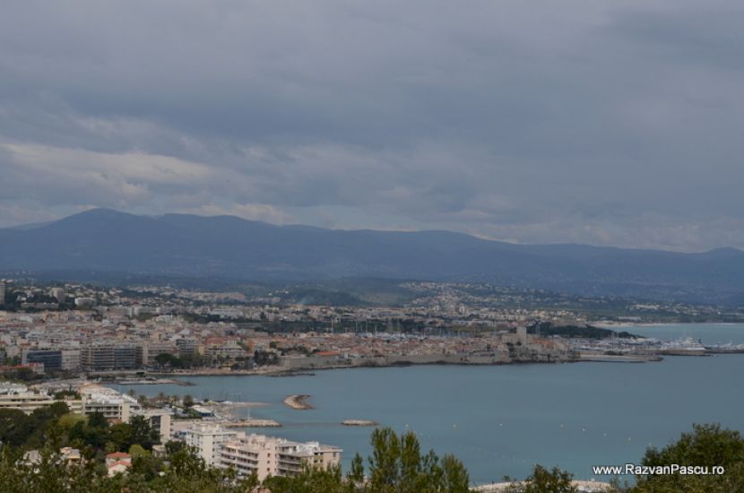 Coastă cu clădiri și mare sub cer înnorat