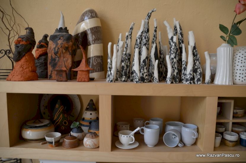 Obiecte ceramice și figurine pe rafturi de lemn