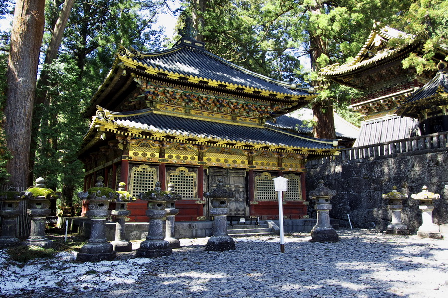 Poartă japoneză ornamentată, între arbori și ziduri