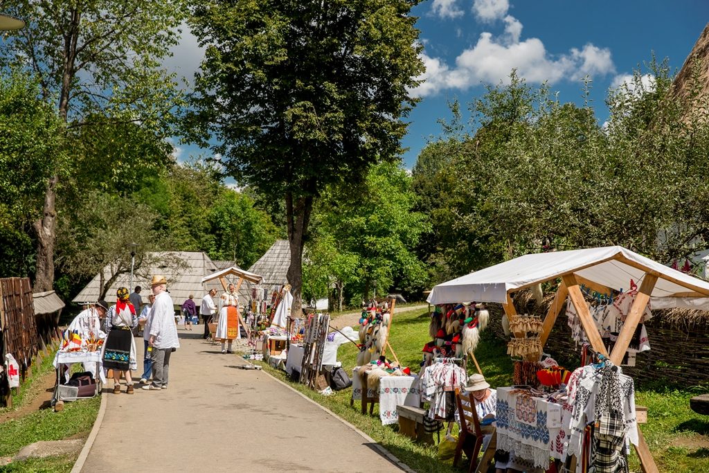 Vizitatori și tarabe într-un târg în aer liber