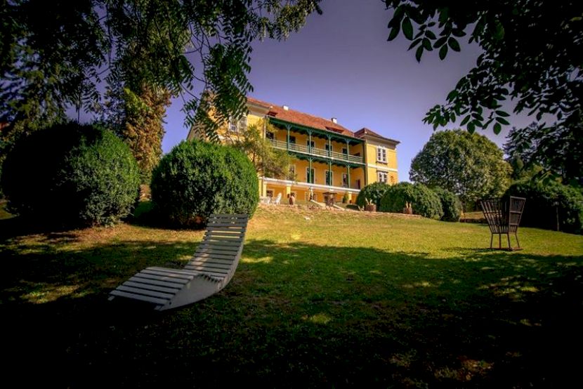 Clădire pe un deal cu șezlonguri în grădină