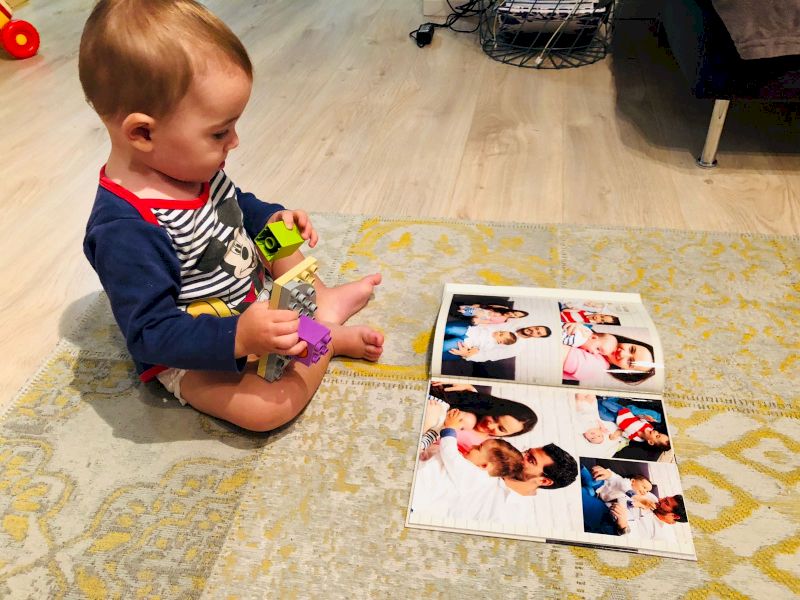 Copil așezat lângă fotografii și calendar