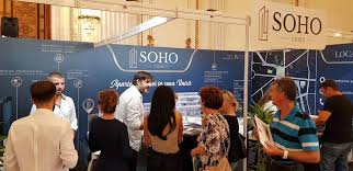 Vizitatori la un stand cu inscripția Soho
