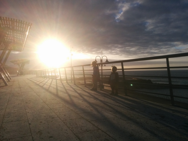 Soare la apus lângă o promenadă cu balustradă