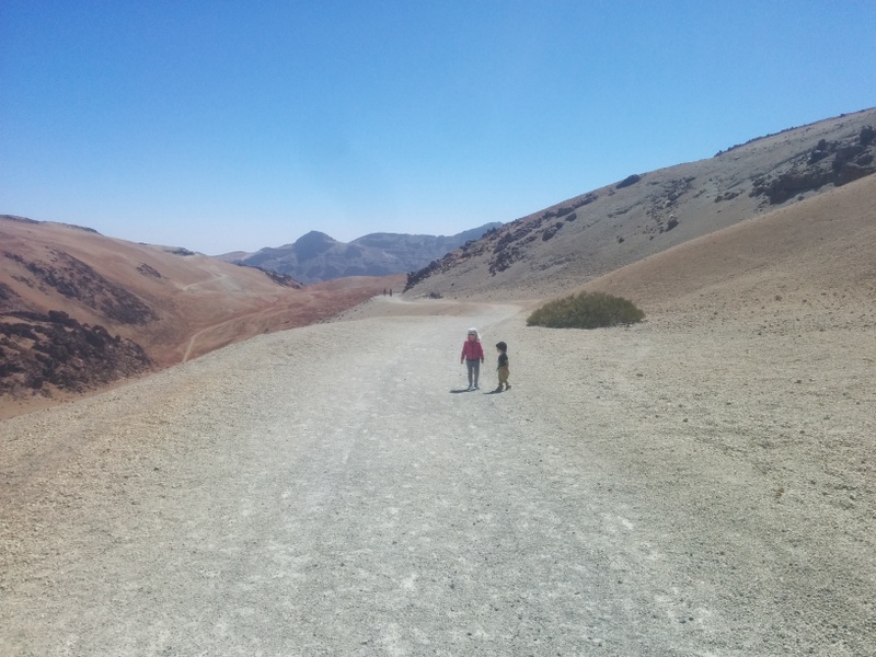 Două persoane pe un traseu montan arid