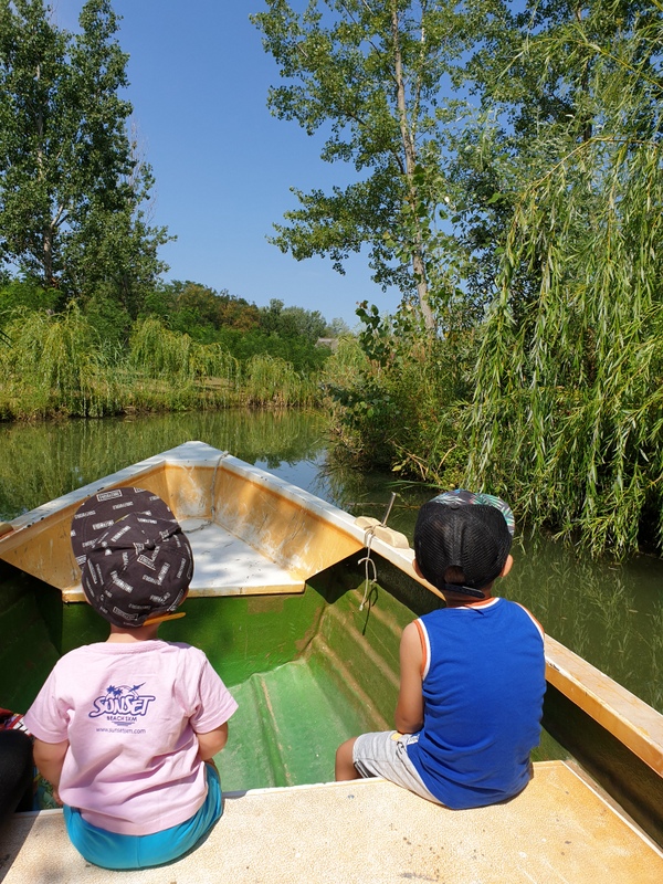 Două persoane într-o barcă de lemn pe lac