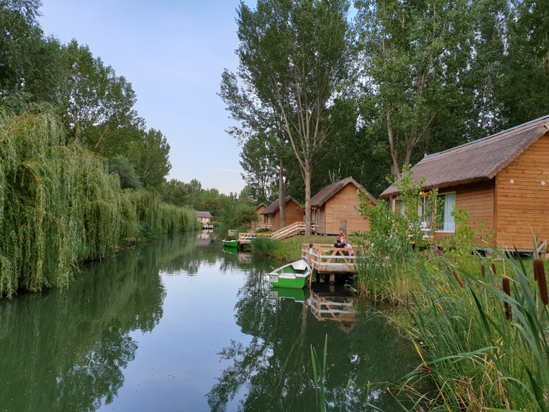 Canal liniștit între sălcii și căsuțe din lemn
