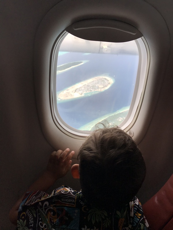 Copil privind insulele prin hubloul unui avion