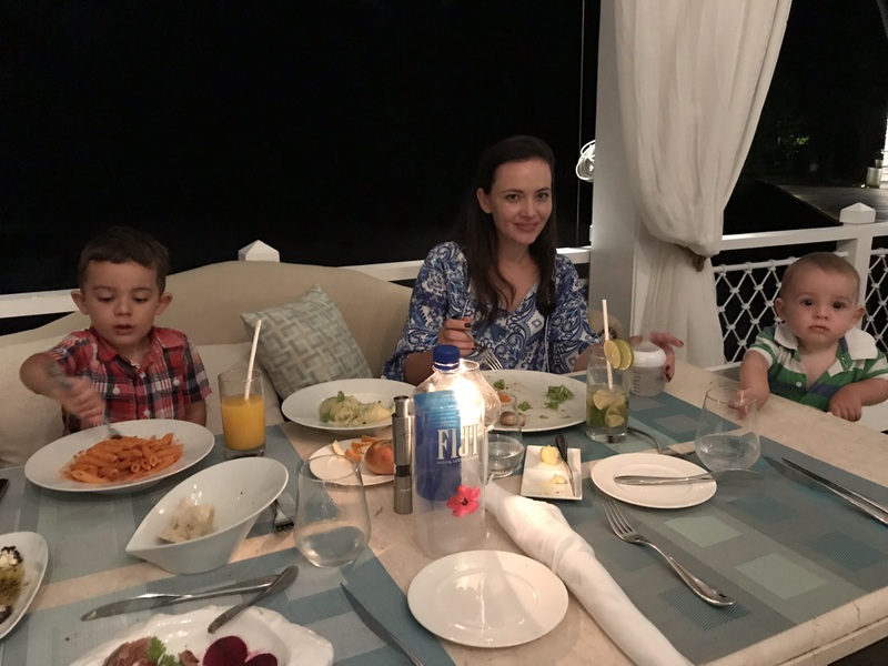Familie la masă pe o terasă nocturnă
