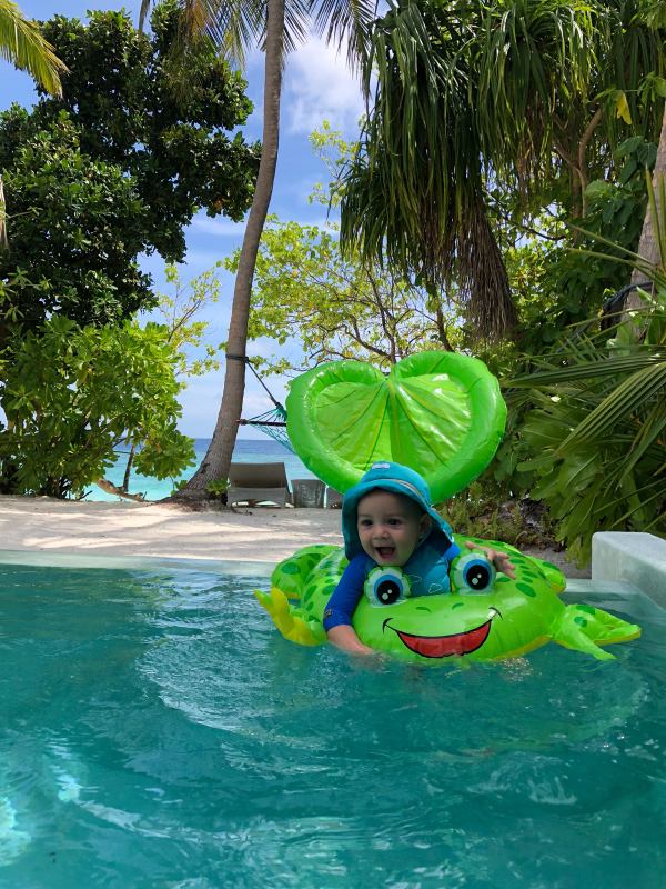 Copil într-un colac verde într-o piscină