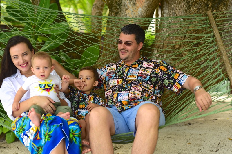 Familie pe un leagăn, într-o grădină tropicală