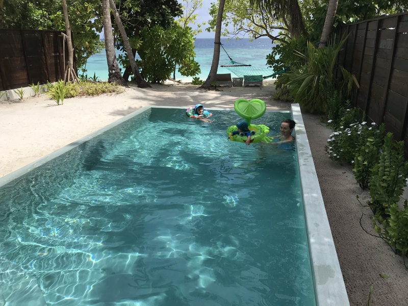 Copil în colac verde într-o piscină lungă