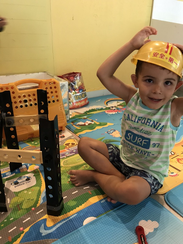 Copil cu pălărie așezat într-o cameră de joacă
