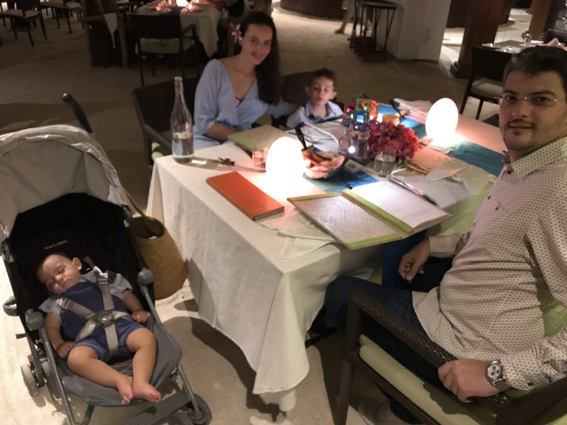 Familie la o masă de restaurant lângă cărucior