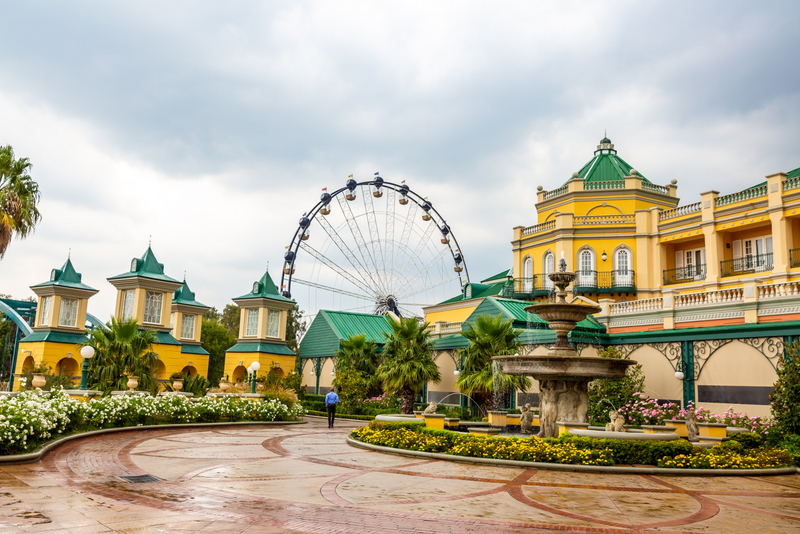 Parc de distracții cu roată panoramică și clădiri