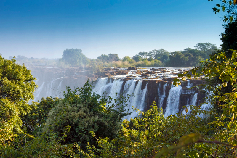 Cascada Victoria văzută dintre arbori și vegetație