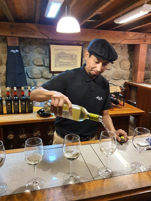 Persoană turnând vin într-un spațiu de degustare