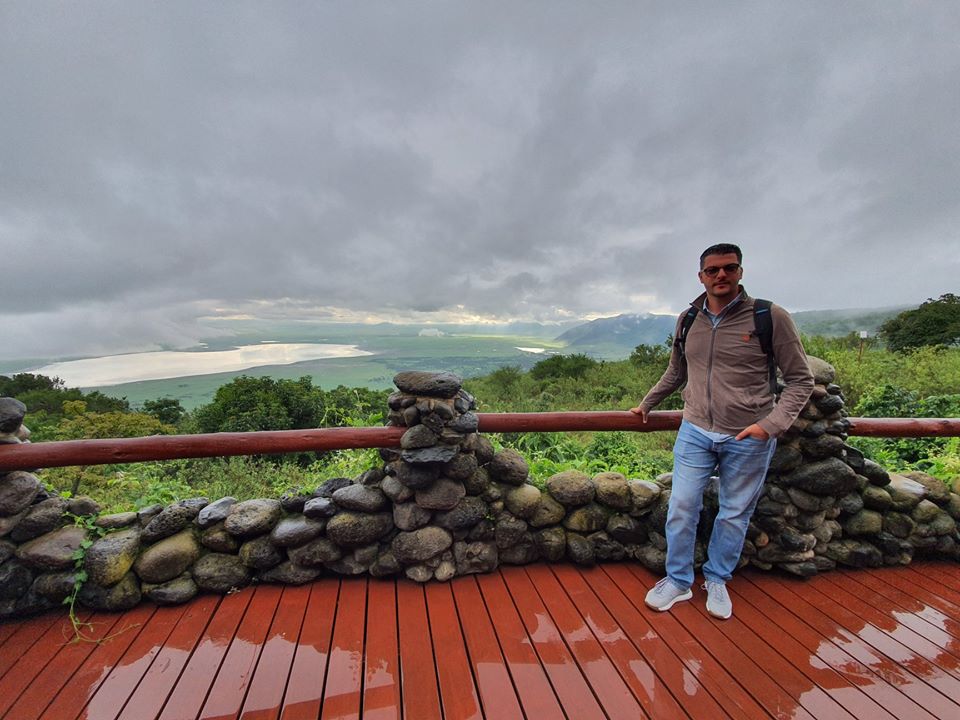 Persoană pe o terasă cu panoramă spre dealuri