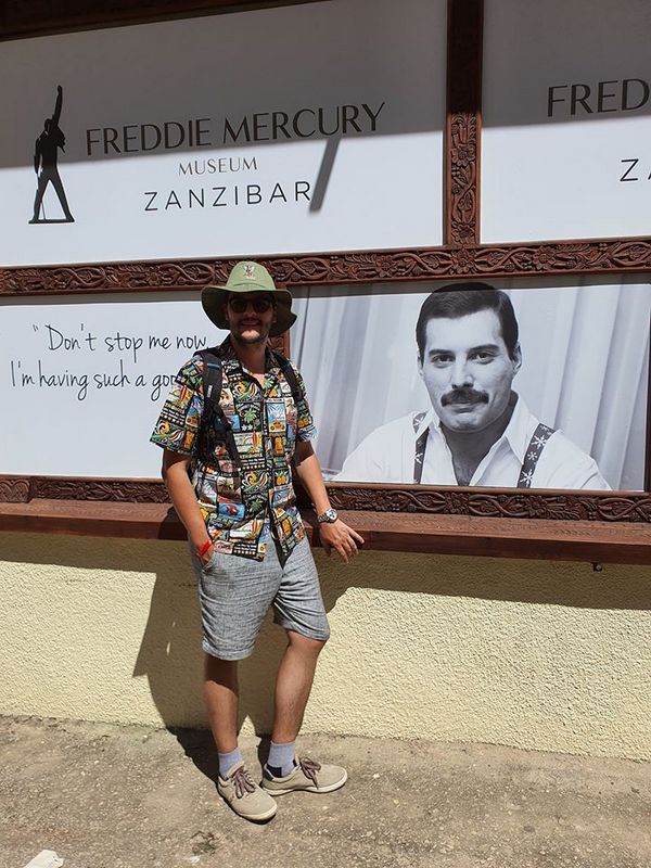 Vizitator lângă panouri cu fotografii ale lui Freddie Mercury