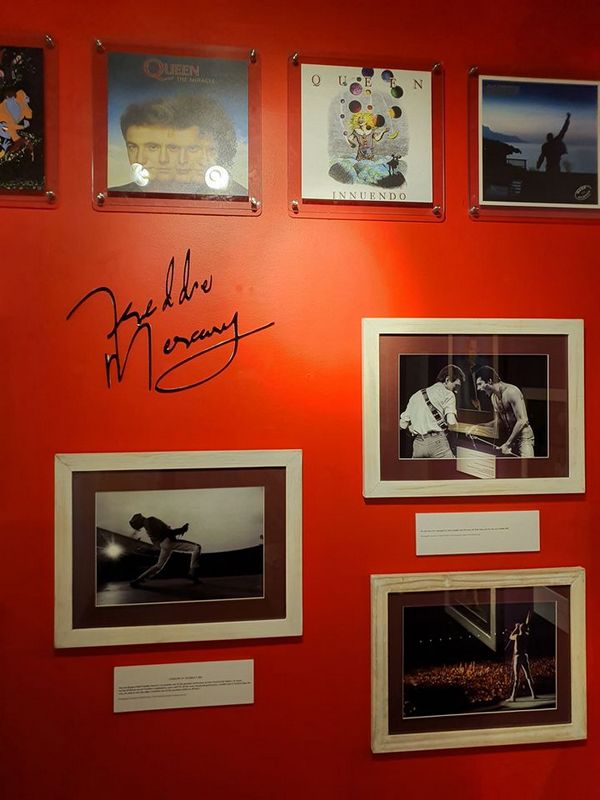 Perete roșu cu fotografii despre Freddie Mercury