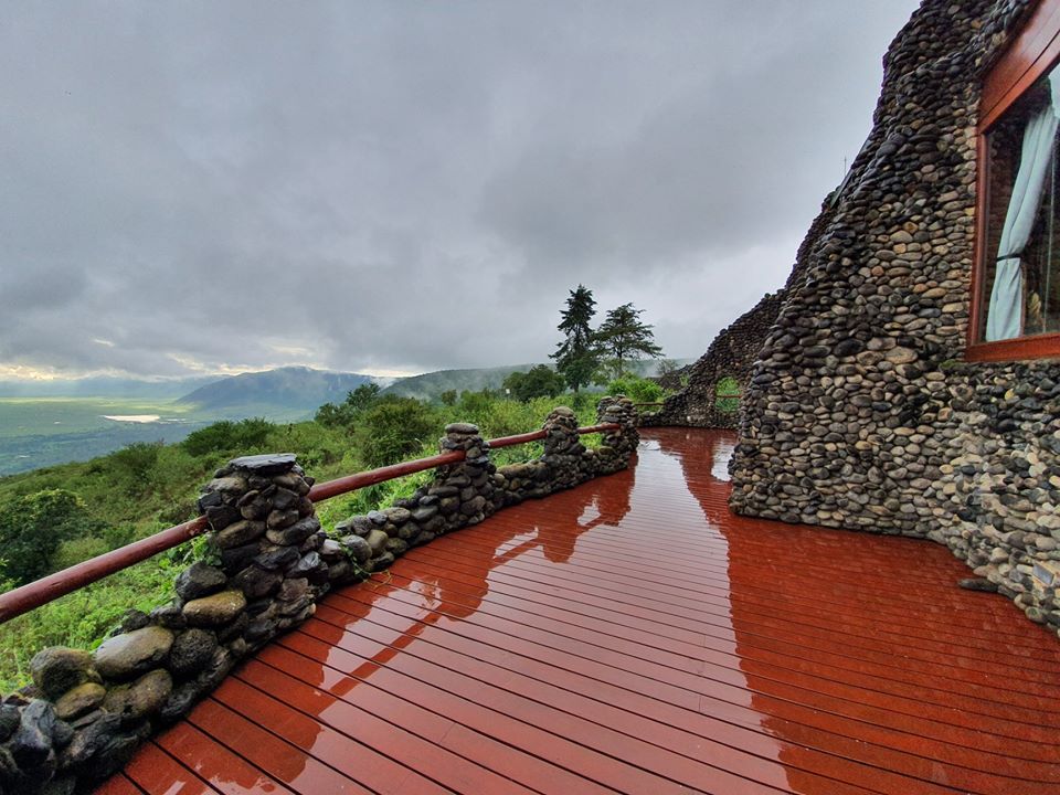 Terasă roșcată cu balustradă, deasupra unui peisaj verde
