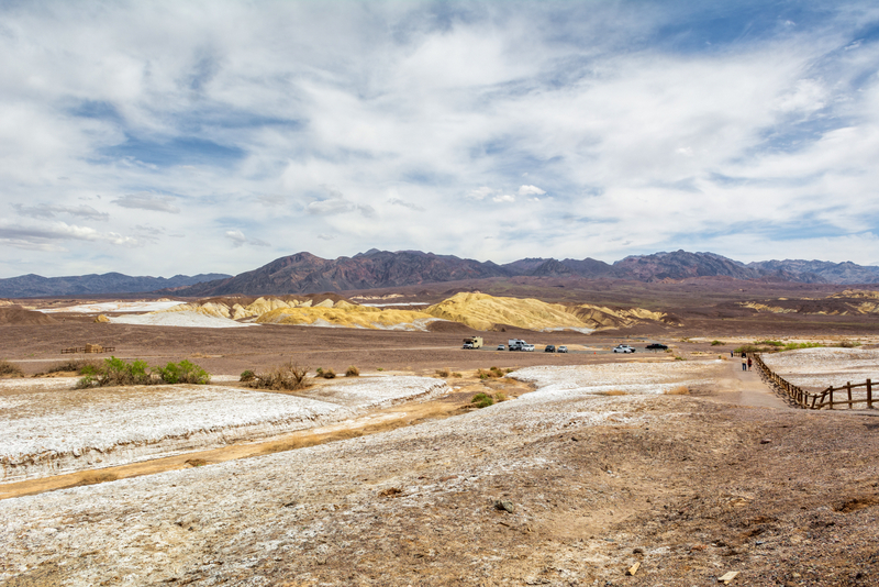 Peisaj arid cu potecă și munți în depărtare