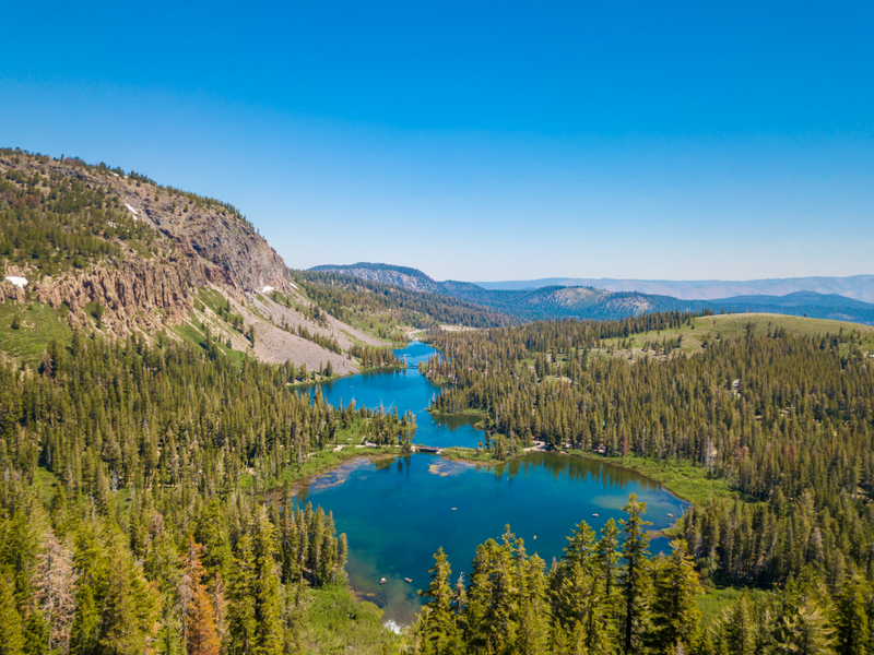 Lac într-o pădure, cu munți în fundal