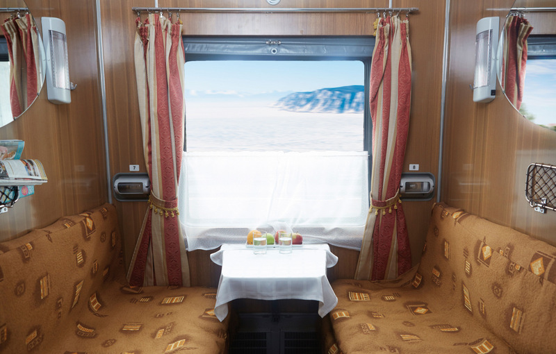 Compartiment de tren cu banchetă și masă la fereastră