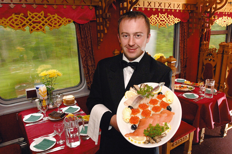 Angajat servind un platou în vagonul de restaurant