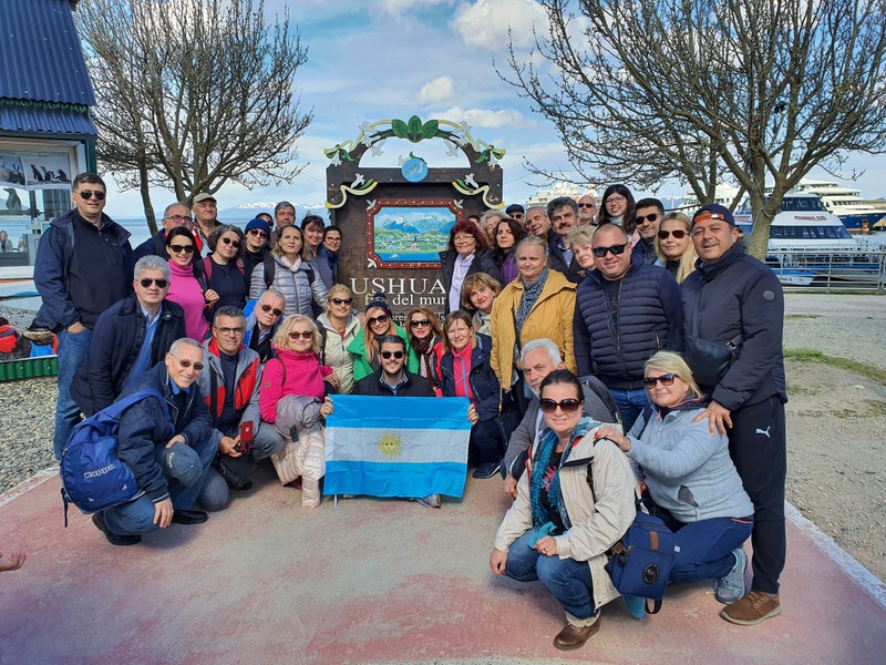 Grup de vizitatori lângă indicatorul Ushuaia
