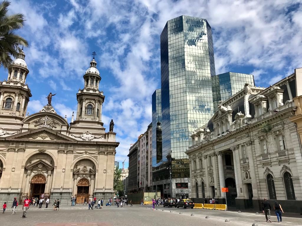 Clădiri istorice și turn modern sub cer albastru