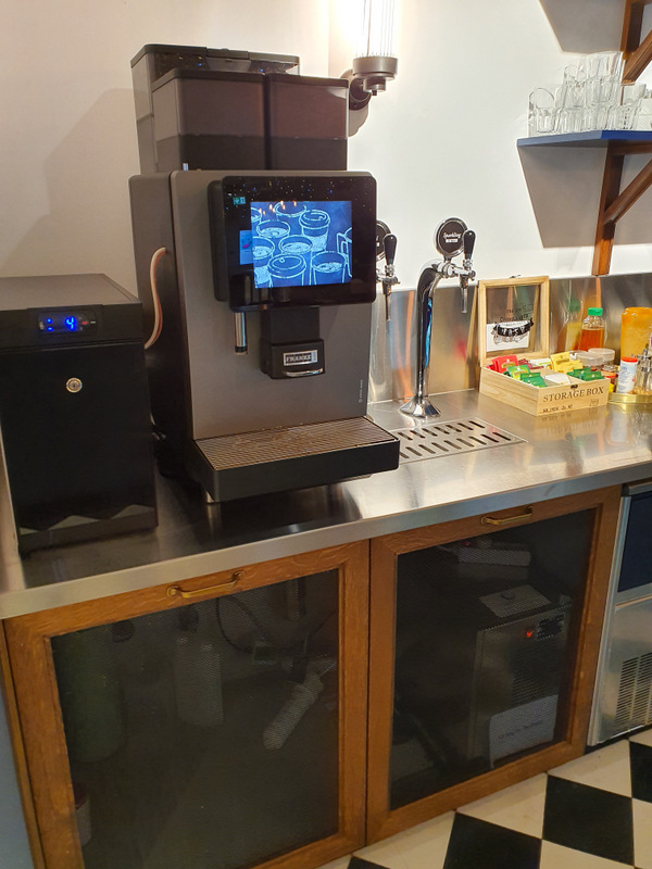Espressor lângă rafturi și băuturi într-un interior
