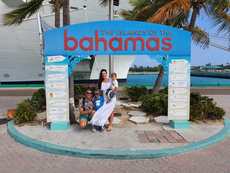 Două persoane lângă inscripția Bahamas pe plajă
