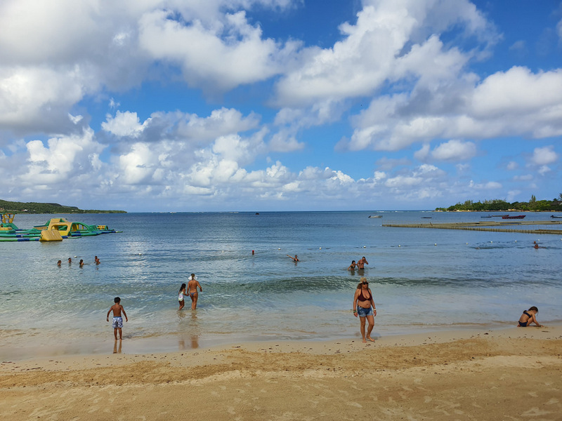 Persoane în mare lângă o plajă nisipoasă