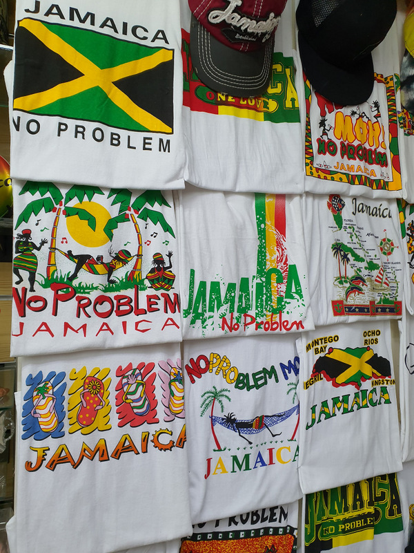 Tricouri și steaguri Jamaica expuse pe un perete